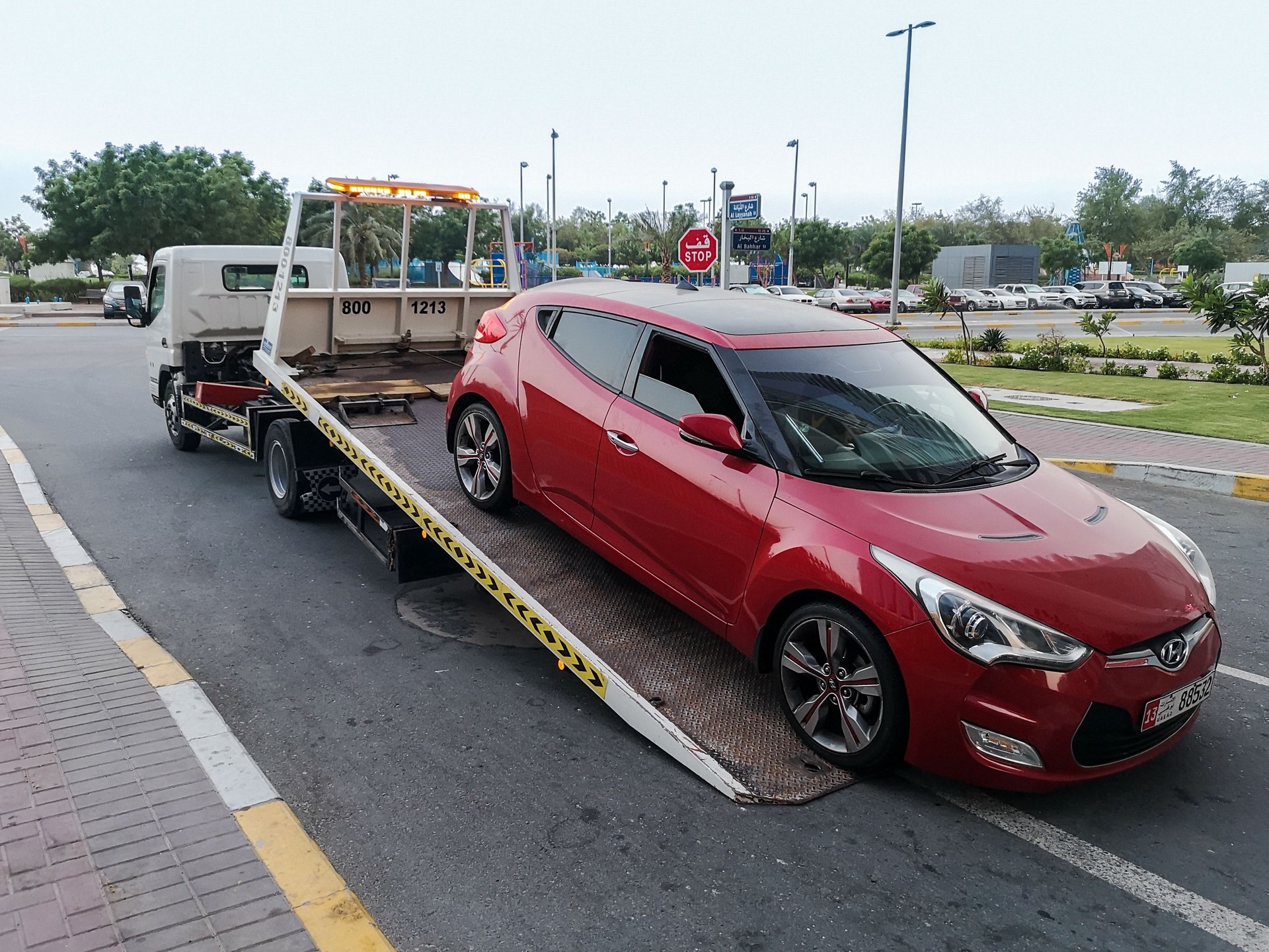 A tow truck (car transporter, lorry) carrying a car for repairing at the city street